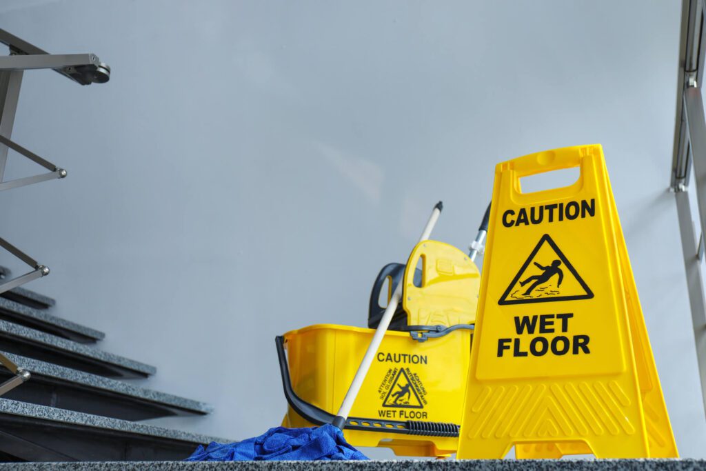 A yellow bucket and mop on the ground