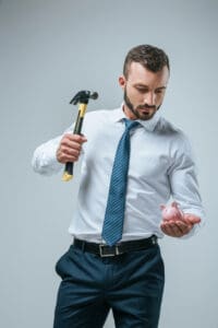 A man holding a hammer and looking at something