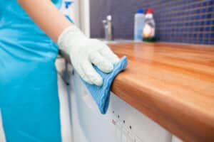 a woman disinfecting a table