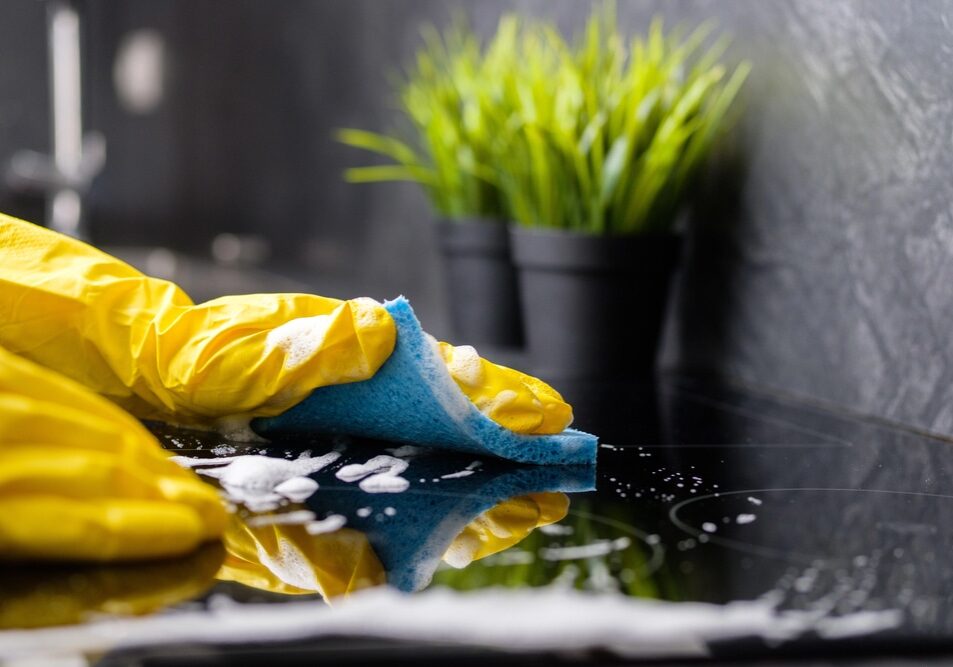 A yellow glove and blue cloth doing commercial cleaning