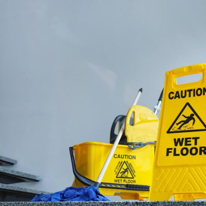 A yellow bucket and mop on the ground