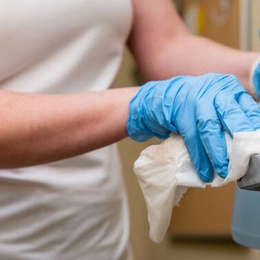 a gulf south janitorial employee disinfecting a door handle